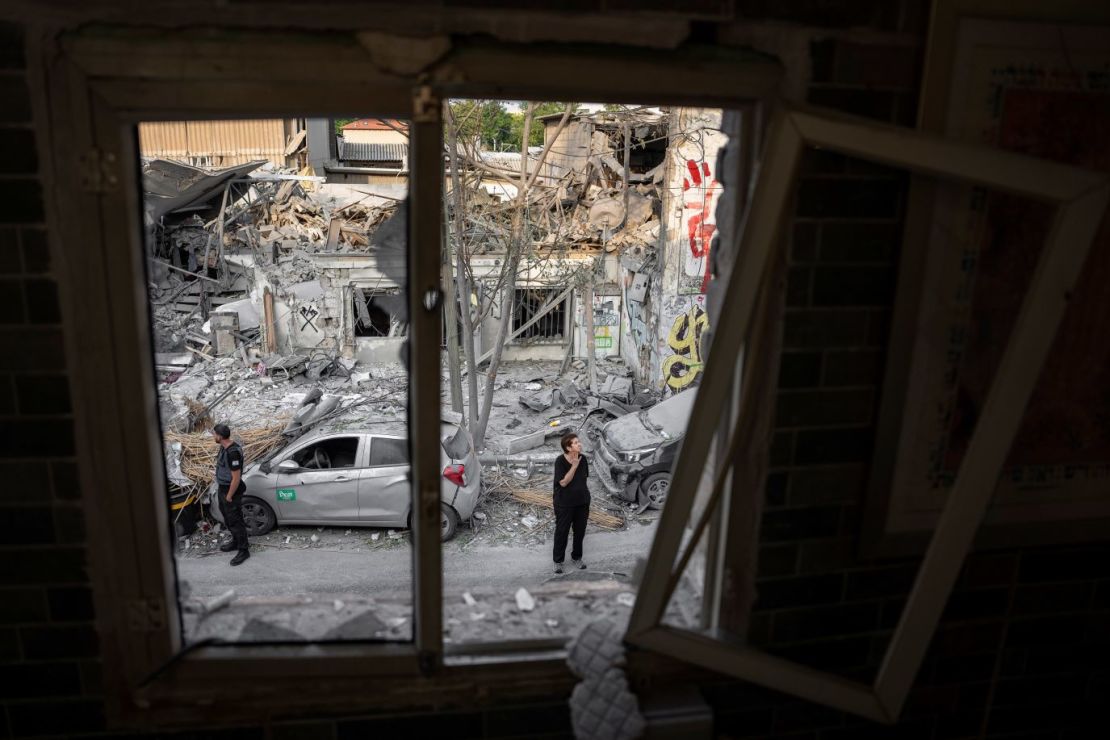 Israelíes inspeccionan los escombros de un edificio en Tel Aviv el 8 de octubre, un día después de que fuera alcanzado por un cohete lanzado desde Gaza.