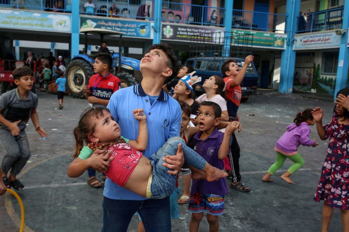 Niños palestinos miran al cielo al oír los ataques aéreos en una escuela istrada por la ONU en Gaza el sábado 7 de octubre.