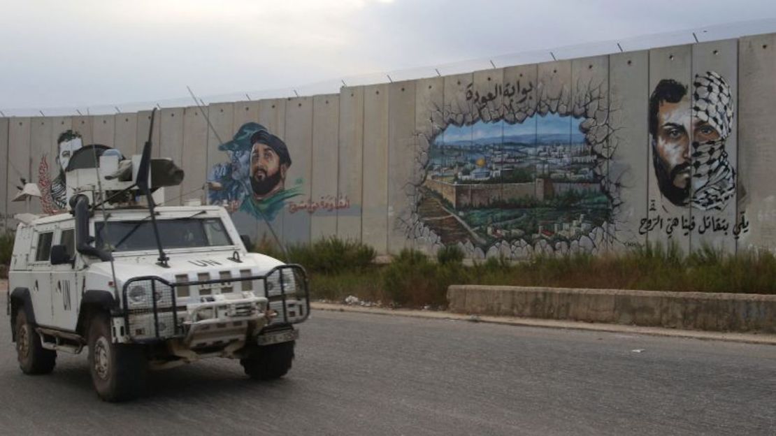 Efectivos de mantenimiento de la paz de la Fuerza Provisional de las Naciones Unidas en el Líbano (FPNUL) patrullan cerca del muro fronterizo con Israel, pintado con el retrato del comandante asesinado de Hezbollah Imad Moghnieh, en la ciudad de Kfar Kila, en el sur del Líbano, el 9 de octubre de 2023.