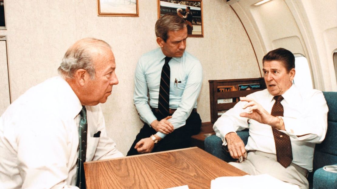 El secretario de Estado George Shultz y el consejero de Seguridad Nacional designado Robert McFarlane escuchan a Reagan hablar sobre los problemas en Beirut en el Air Force One, el 23 de octubre de 1983.