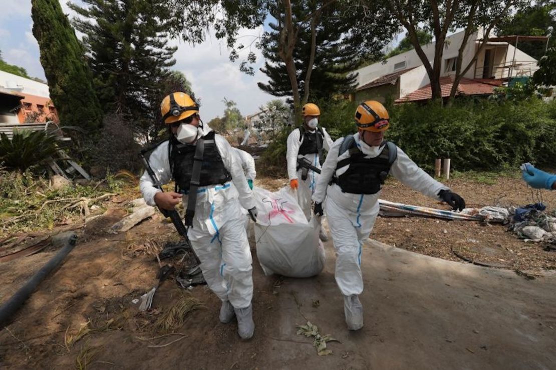 Soldados israelíes cargan el cuerpo de un militante de Hamas en el Kibbutz Be'eri el miércoles 11 de octubre de 2023