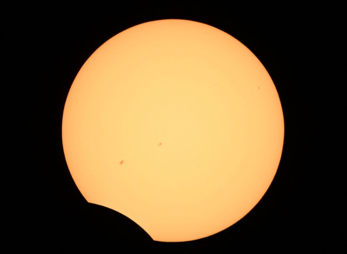 La luna (abajo) cruza el sol al final del eclipse solar anular sobre Albuquerque, Nuevo México, el 14 de octubre de 2023.