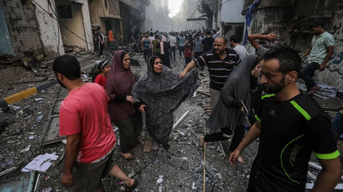 Personas en el lugar de un ataque con cohetes israelíes en el campo de refugiados de Al-Shati, en el oeste de la ciudad de Gaza, el 14 de octubre.