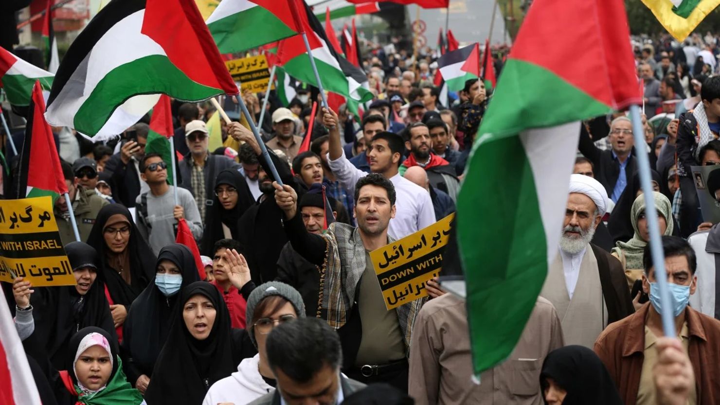 La gente asiste a la manifestación a favor de Palestina mientras sostienen pancartas y banderas en la calle de la Revolución en Teherán el 13 de octubre de 2023. Crédito: Fatemeh Bahrami/Anadolu/Getty Images