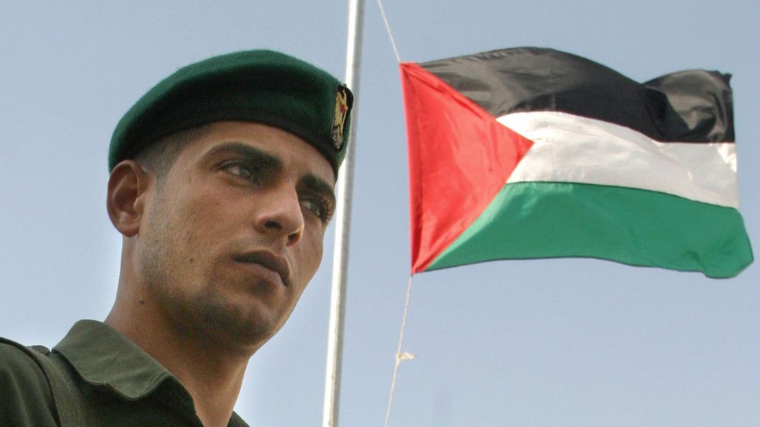 Un guardia de seguridad palestino frente a la bandera del Gobierno Autónomo Palestino, el 5 de noviembre de 2004, en Ramallah.