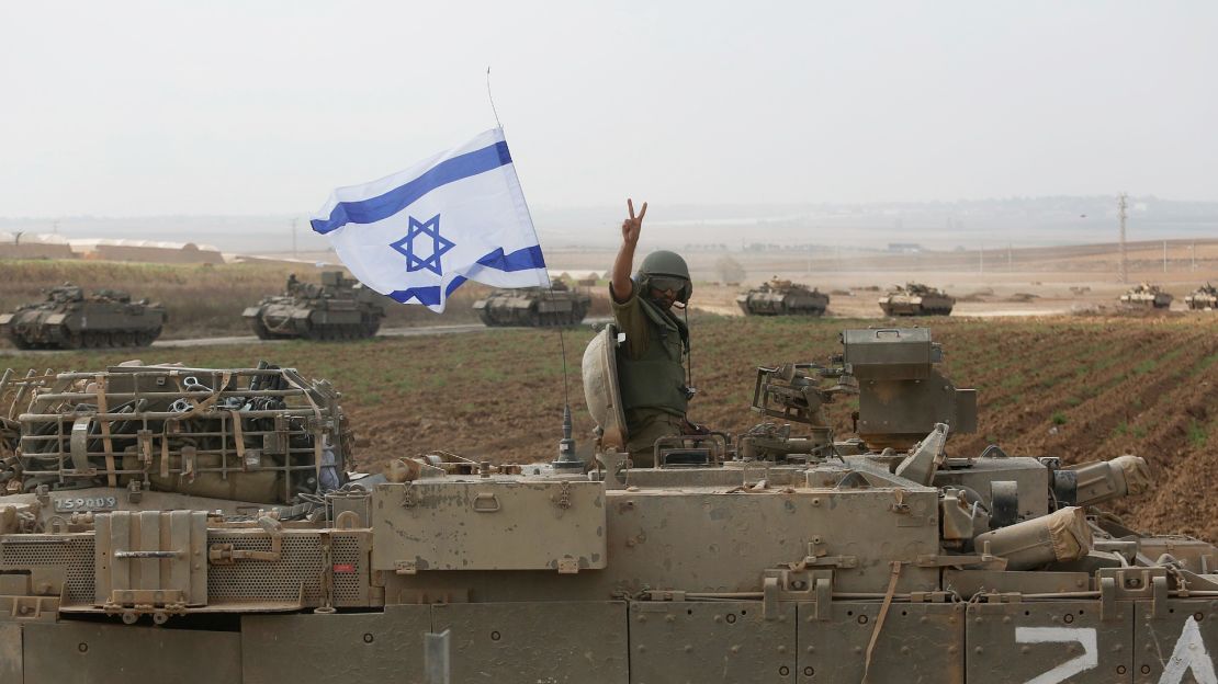Un soldado posa para las fotos encima de un vehículo blindado cerca de la frontera con Gaza, el 14 de octubre de 2023, en los alrededores de Sderot, Israel.