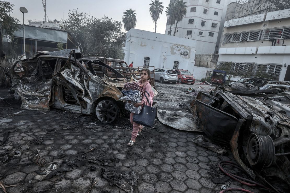 Una niña trata de recoger sus pertenencias entre los restos de los vehículos destruidos por el ataque al Hospital Bautista Al-Ahli, en la Ciudad de Gaza, el 18 de octubre. Ali Jadallah/Anadolu/Getty Images