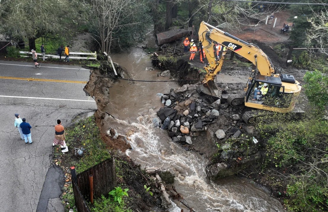 Los trabajadores realizan reparaciones de emergencia en una carretera que fue arrasada por las fuertes lluvias el 10 de marzo de 2023 en Soquel, California.