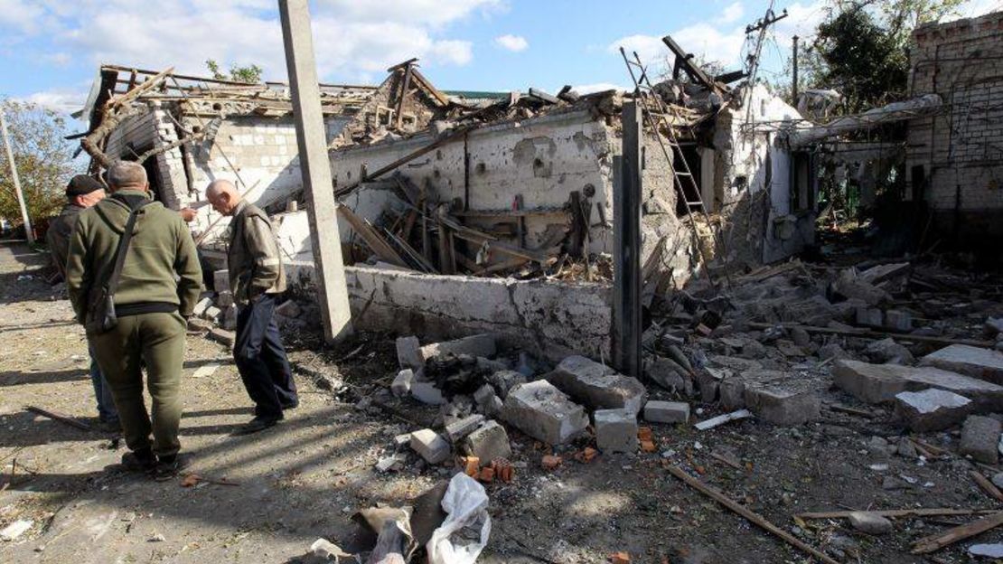 Hombres se encuentran afuera de una casa destruida en el ataque con cohetes rusos que tuvo lugar el miércoles 18 de octubre por la mañana en Obukhivka, región de Dnipropetrovsk, Ucrania central.