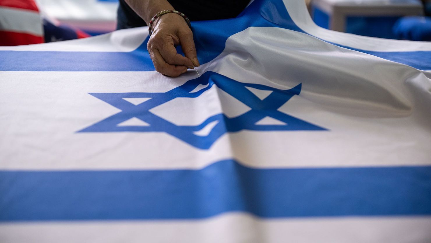 Una costurera pone alfileres en una bandera israelí en la fábrica de Marom el 22 de octubre de 2023 en Kfar Saba, Israel. Crédito: Alexi J. Rosenfeld/Getty Images