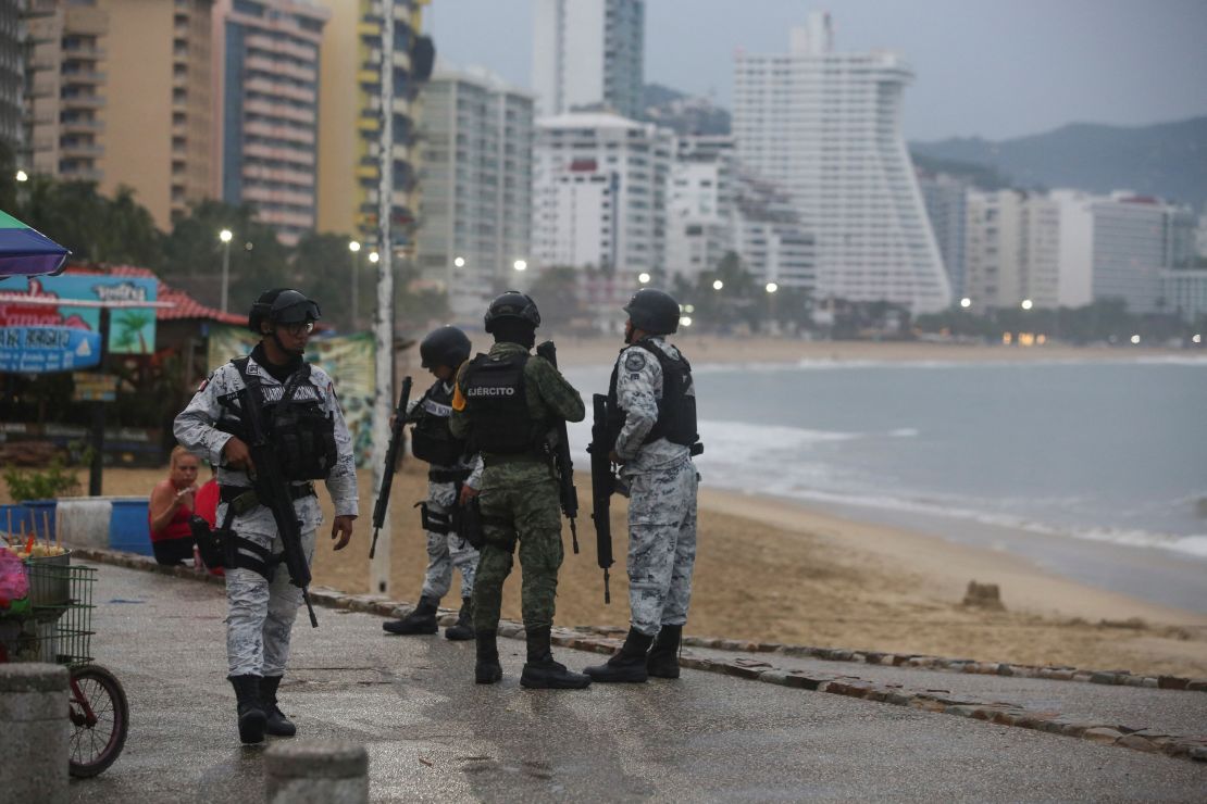 Miembros de las fuerzas federales charlan mientras vigilan en una playa a medida que el huracán Otis se acerca a Acapulco, México, 24 de octubre de 2023.