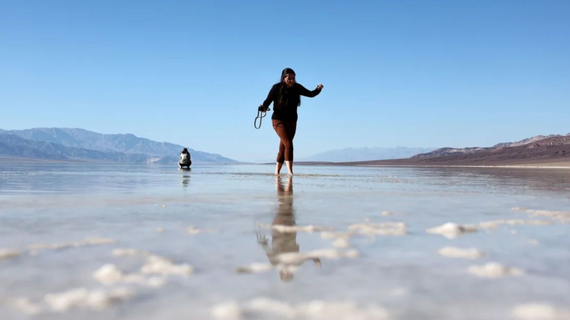 Una visitante camina por el extenso lago temporal en las salinas de la cuenca Badwater en el Parque Nacional del Valle de la Muerte el 21 de octubre de 2023.