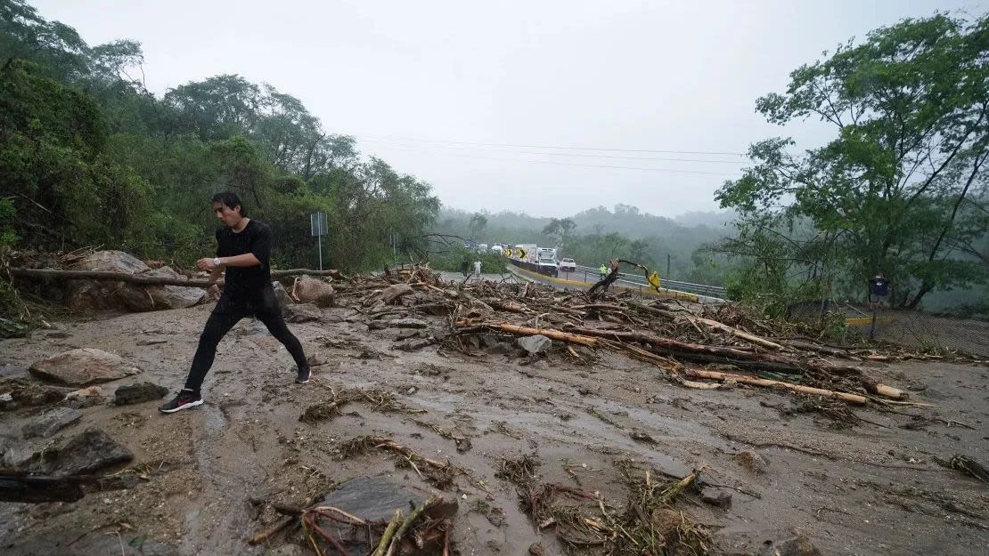 Un hombre cruza una carretera bloqueada por un deslizamiento de tierra causado por el huracán Otis cerca de Acapulco, México, el miércoles 25 de octubre de 2023. Crédito: Marco Ugarte/AP