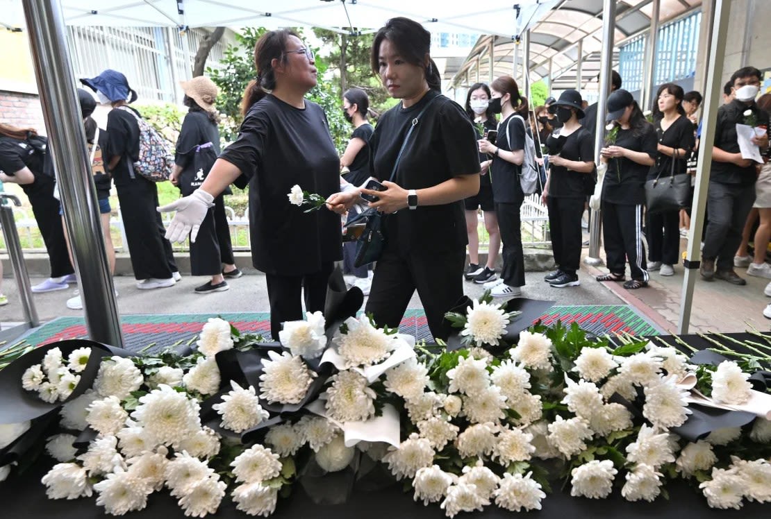 Personas depositan flores frente a un altar a un maestro de escuela primaria que murió en un aparente suicidio en julio en una escuela primaria en Seúl, el 4 de septiembre de 2023.