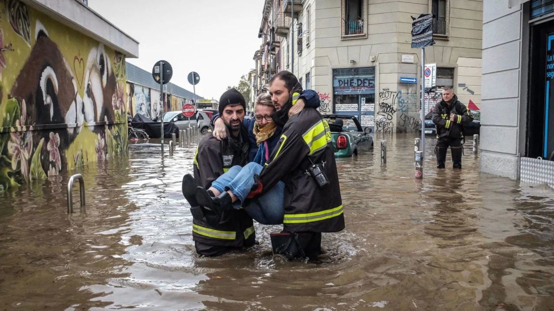 Trabajadores de emergencia cargan a una mujer después de que una tormenta provocara el desbordamiento del río Seveso en Milán, Italia, el 31 de octubre de 2023.