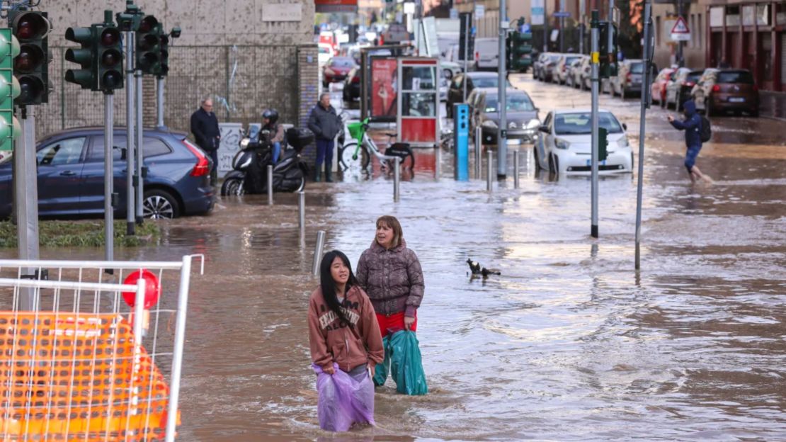 Dos mujeres en una intersección inundada en Milán después de que una violenta tormenta azotara la ciudad el 31 de octubre de 2023.