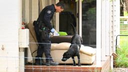 Un agente de policía y un perro investigan la propiedad de Erin Patterson en Leongatha, Australia, tras su detención en la investigación de un presunto incidente de envenenamiento por setas que dejó tres muertos.