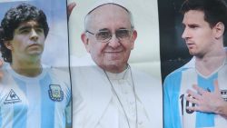 KAZAN, RUSSIA - JUNE 30:  Pictures of Diego Armando Maradona, Pope Francis anf Lionel Messi are shown by an Argentina fan prior to the 2018 FIFA World Cup Russia Round of 16 match between France and Argentina at Kazan Arena on June 30, 2018 in Kazan, Russia.