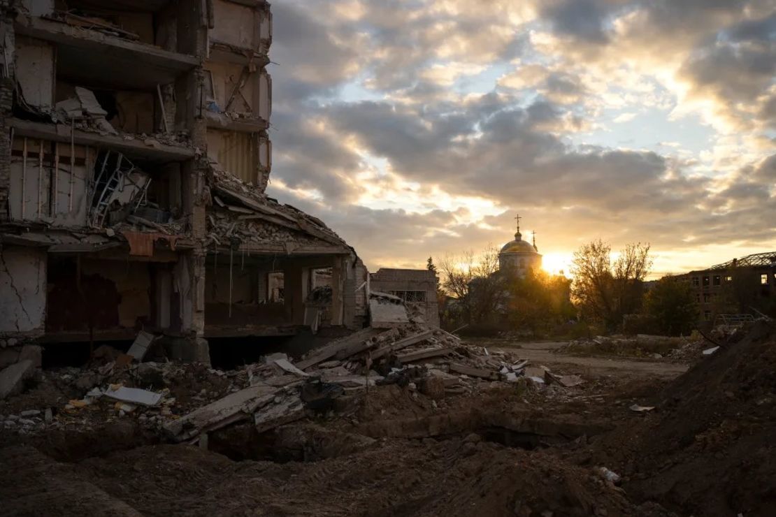 El sol se pone tras un edificio destruido en Izium, Ucrania. Crédito: Bram Janssen/AP