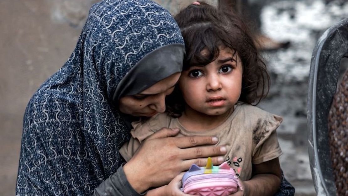 Una familia palestina sentada cerca de casas destruidas tras un ataque en Rafah, en el sur de la Franja de Gaza, el 6 de noviembre de 2023.