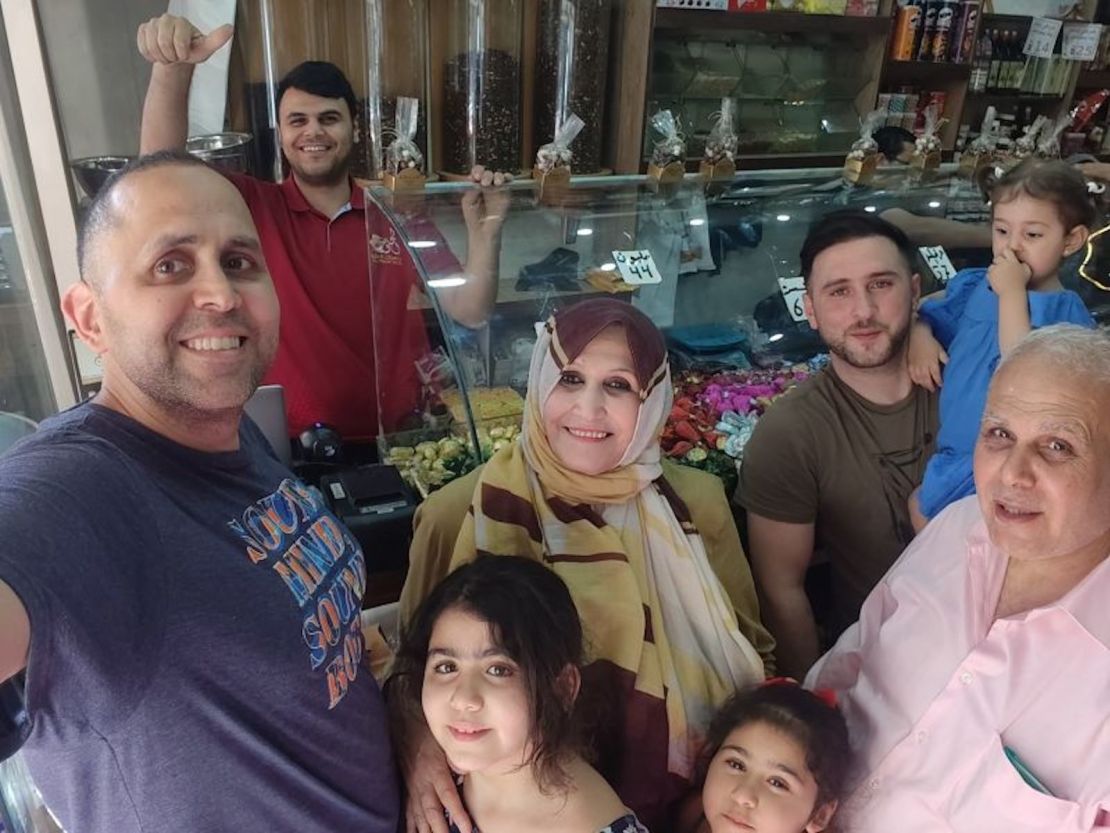 Tiempos más felices: el escritor Hani Almadhoun (izquierda) comprando dulces de Eid con su familia en la ciudad de Gaza durante una visita a su país en verano.