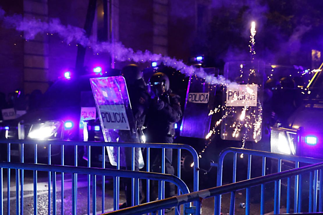 Miembros de la policía antidisturbios usan sus escudos para protegerse de los elementos lanzados por los manifestantes en Madrid, España, el 9 de noviembre de 2023.