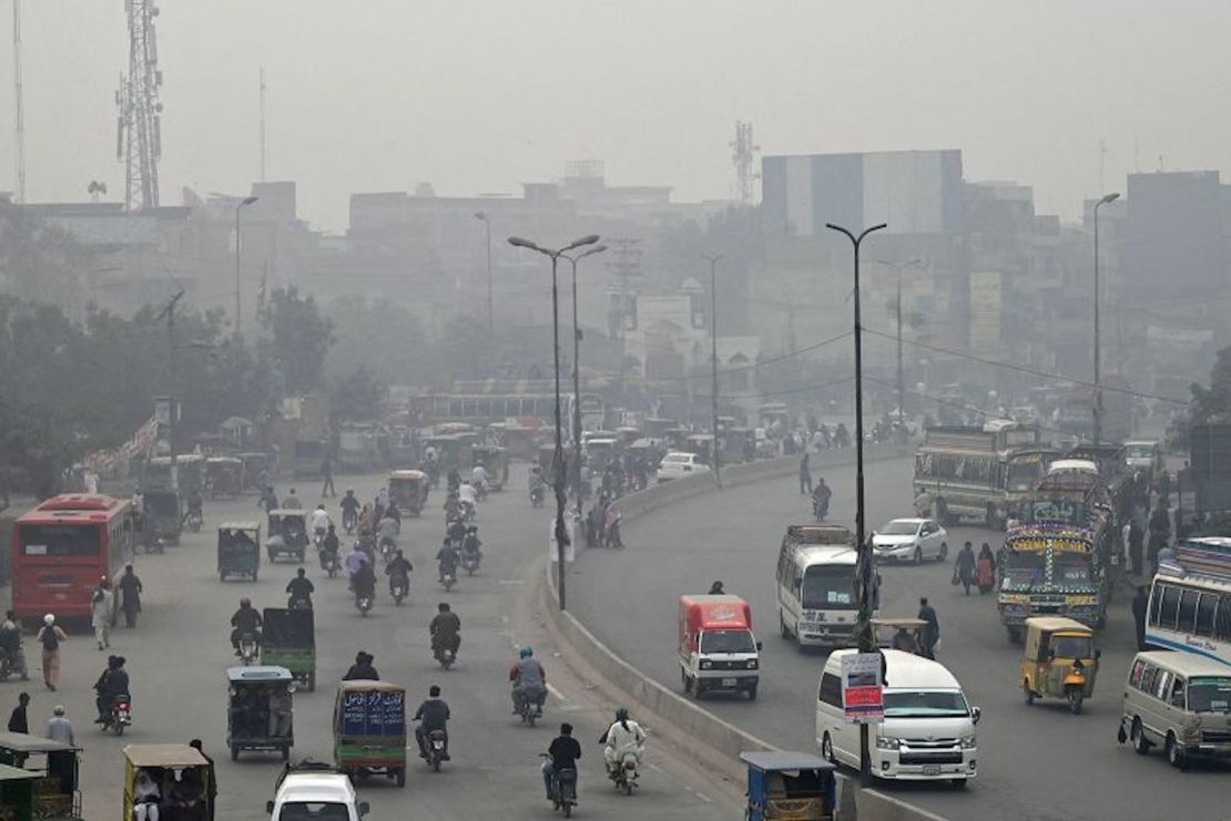 Los transeúntes se abren paso a través de una concurrida calle en medio de la niebla tóxica en Lahore el 7 de noviembre de 2023.