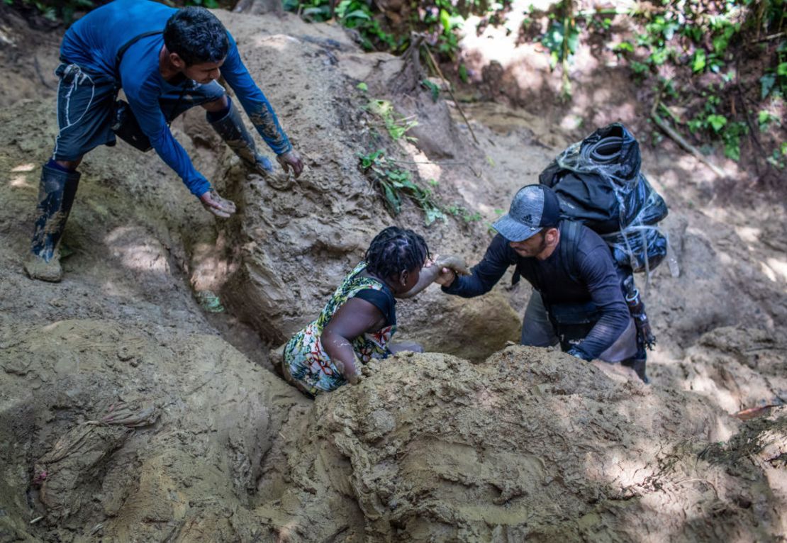 Ayudan a una mujer de Haití después de que se desplomó en el barro durante una caminata a través del Tapón del Darién en su viaje hacia los Estados Unidos el 5 de octubre de 2021 cerca de Acandi, Colombia. Crédito: John Moore/Getty Images.