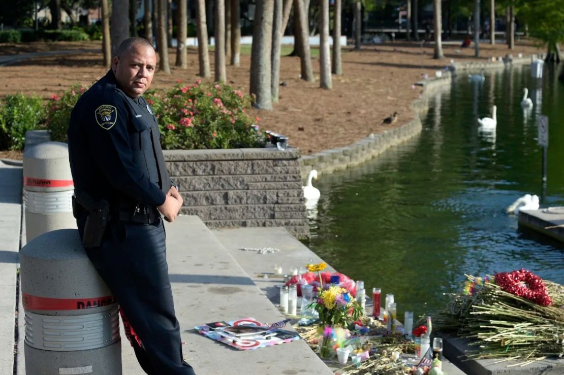 Omar Delgado, agente del Departamento de Policía de Eatonville, junto a un monumento improvisado en memoria de las víctimas del tiroteo en la discoteca Pulse, en el lago Eola, el jueves 23 de junio de 2016, en Orlando.