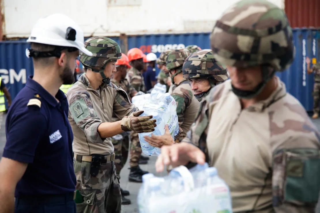 Los soldados descargan bolsas de agua tras la llegada de un barco a la isla francesa de Mayotte que transportaba 600.000 litros de agua embotellada para distribuirla entre las personas más vulnerables del departamento, el 20 de septiembre de 2023.