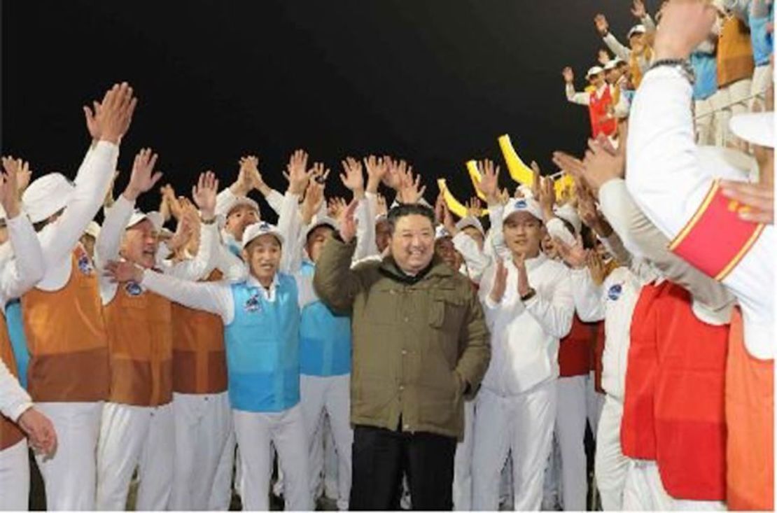 El líder norcoreano Kim Jong Un celebra el lanzamiento del satélite del martes por la noche con trabajadores en una imagen facilitada por los medios estatales.