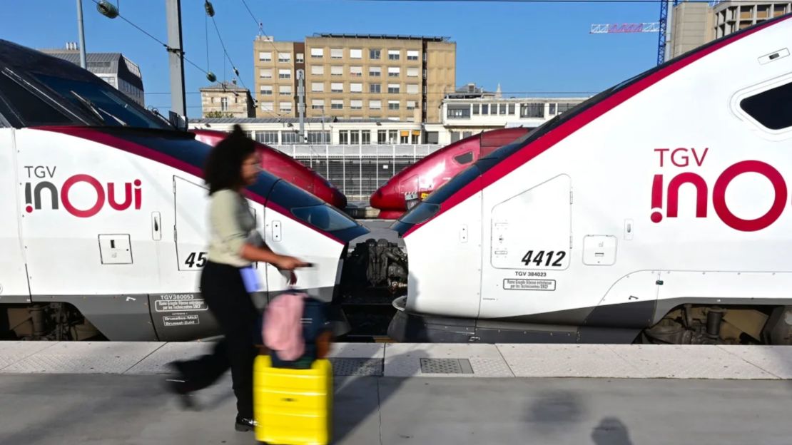 Una pasajera camina con equipaje junto a un tren de alta velocidad TGV en los andenes de la estación Gare du Nord de París, el 7 de octubre de 2023.