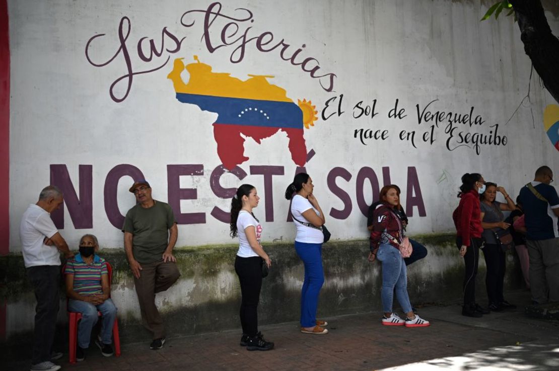 La gente hace cola para votar fuera de un colegio electoral durante un referéndum consultivo simulado sobre la soberanía venezolana sobre el Esequibo, en Caracas el 19 de noviembre de 2023.