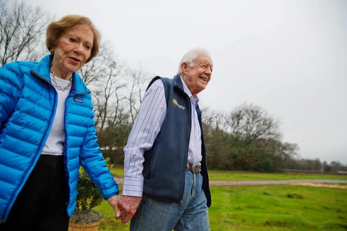 En esta foto de archivo del 8 de febrero de 2017, el expresidente Jimmy Carter, a la derecha, y su esposa Rosalynn llegan para una ceremonia de corte de cinta para un proyecto de paneles solares en tierras de cultivo que posee en su ciudad natal de Plains. Crédito: David Goldman/AP