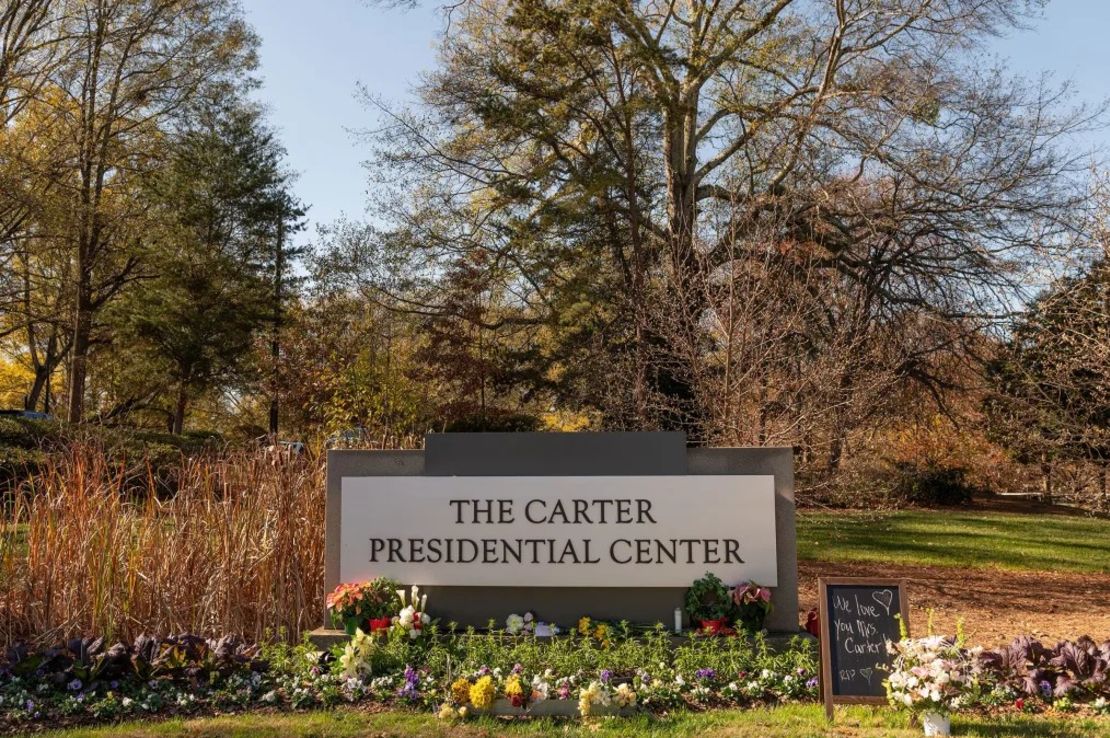 Flores depositadas en la base de un cartel a la entrada del Centro Presidencial Carter en Atlanta el 27 de noviembre. Crédito: Will Lanzoni/CNN