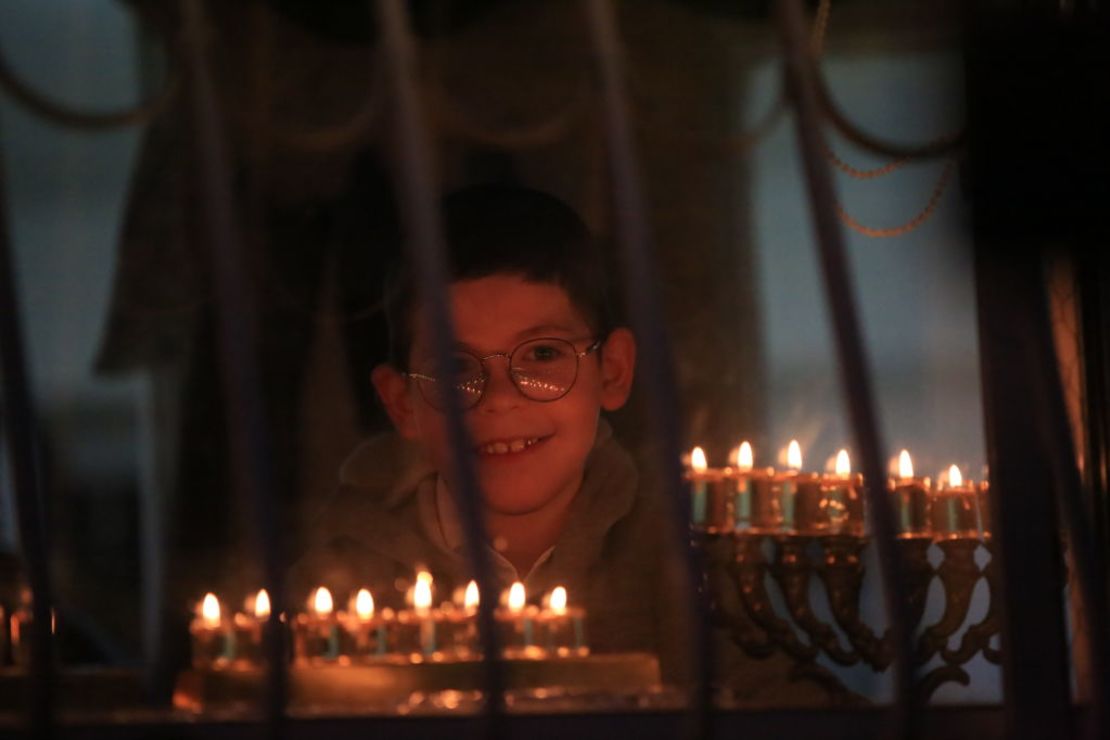 Un niño sonríe ante la menorá, durante las celebraciones de Janucá, en la Ciudad Vieja de Jerusalém, Israel.