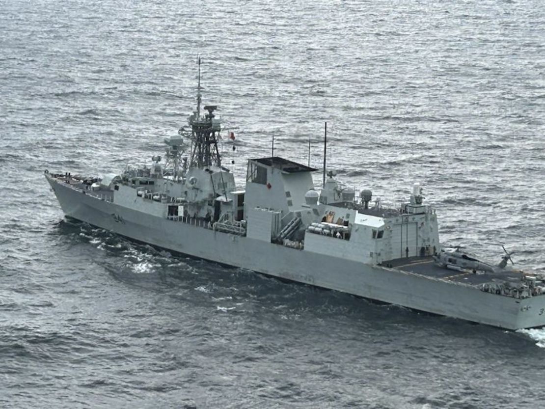 La fragata canadiense HMCS Ottawa es vista desde el helicóptero del barco mientras un helicóptero de la Armada de EE.UU. descansa en su cubierta de vuelo en el Mar de China Oriental.