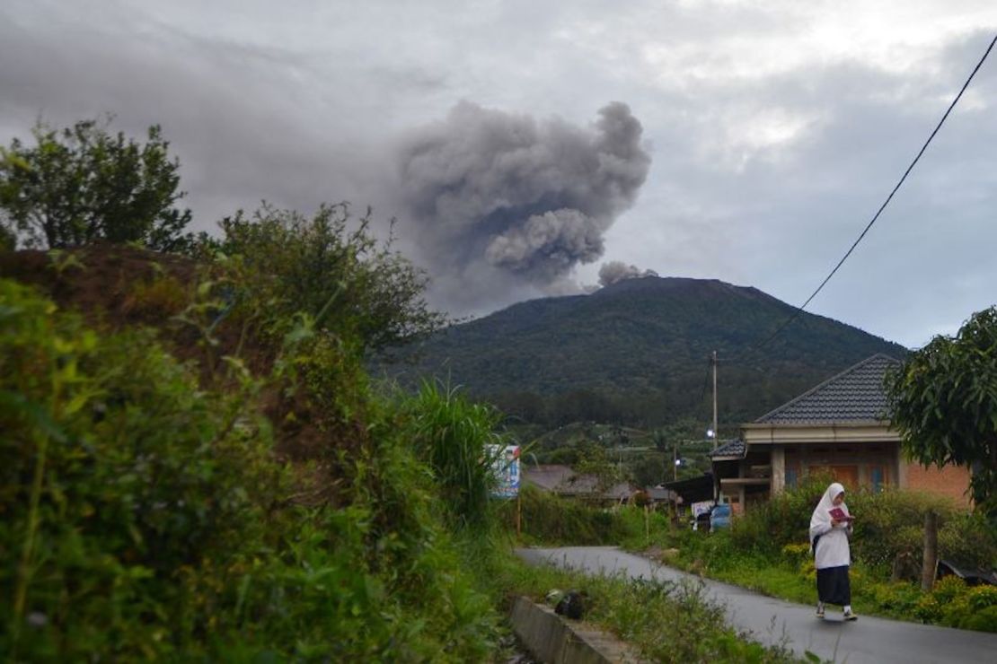 Un estudiante camina mientras el volcán Marapi arroja ceniza volcánica visto desde Nagari Batu Palano en Agam, provincia de Sumatra Occidental, Indonesia, 4 de diciembre de 2023.