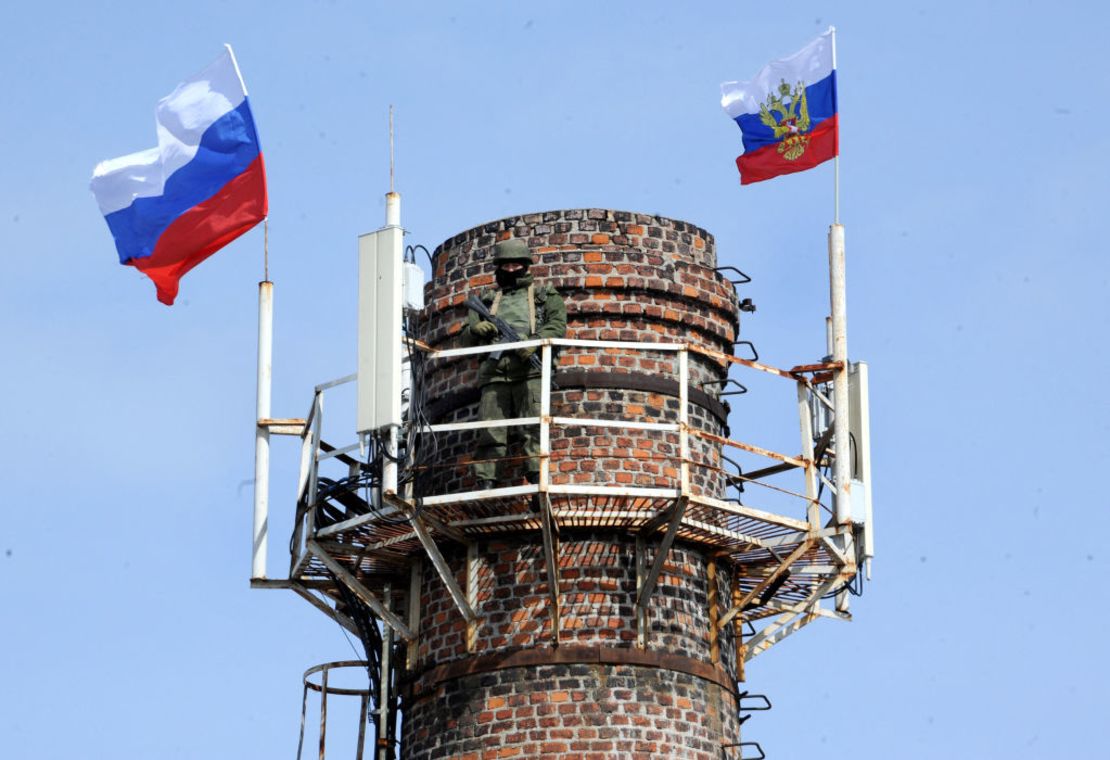 Un soldado ruso patrulla sobre una chimenea con banderas rusas en el cuartel general de la marina ucraniana en la ciudad de Sebastopol en Crimea, el 19 de marzo de 2014.