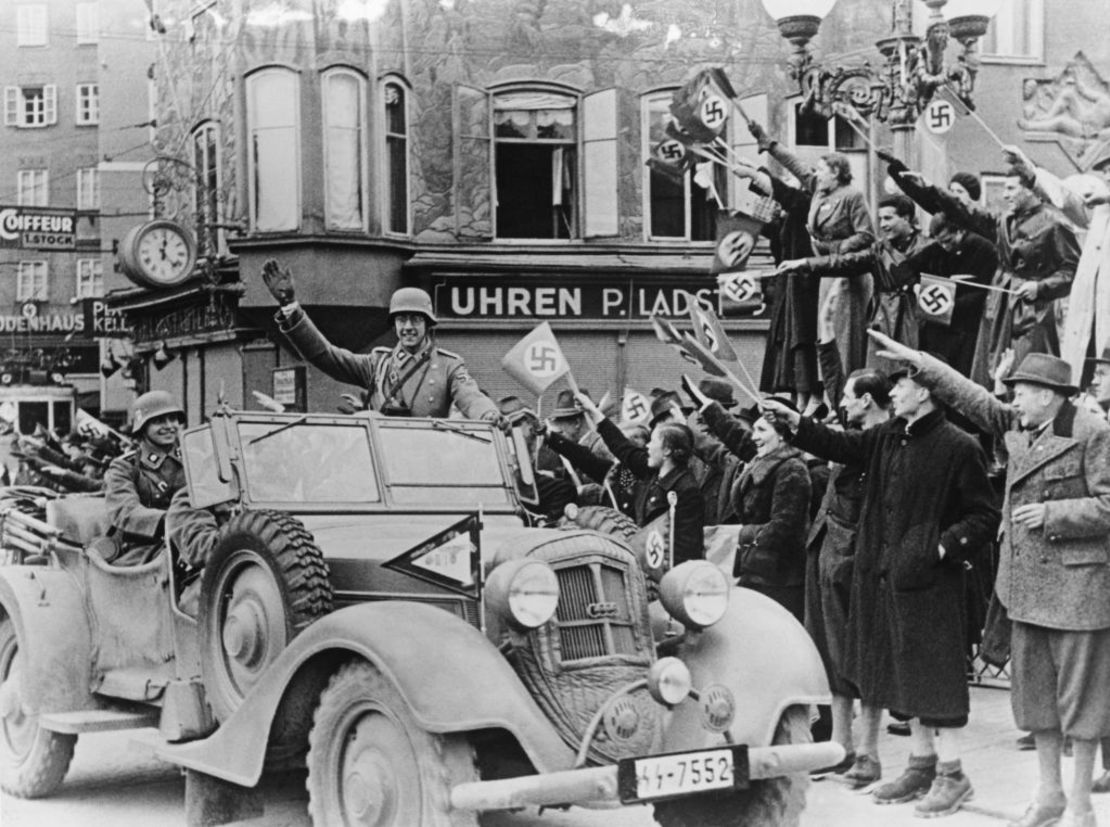 Ciudadanos austriacos celebran haciendo el saludo nazi mientras tropas alemanas de la 2ª División Panzer SS "Das Reich" recorren las calles de Salzburgo, Austría, el 12 de marzo de 1938.