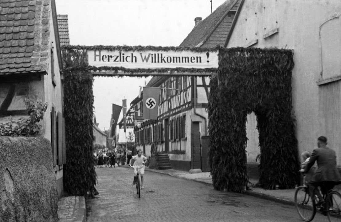 Un cartel de bienvenida y una esvástica en una feria anual en la ciudad de Schifferstadt, Alemania, en la década del 30.