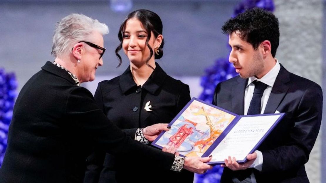 Berit Reiss-Andersen, presidenta del Comité Nobel, entrega a Ali y Kiana Rahmani, hijos de Narges Mohammadi, activista iraní de derechos humanos encarcelada, el Premio Nobel de la Paz 2023, mientras aceptan el galardón en nombre de su madre en una ceremonia celebrada en Oslo.