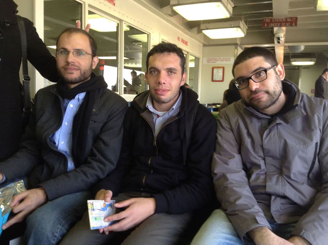 Refaat Alareer (izquierda) sentado con sus amigos y colegas, Yousef Aljamal (centro) y Jehad Abusalim (derecha), en el transbordador de Staten Island, en Nueva York, durante una gira literaria en 2014.