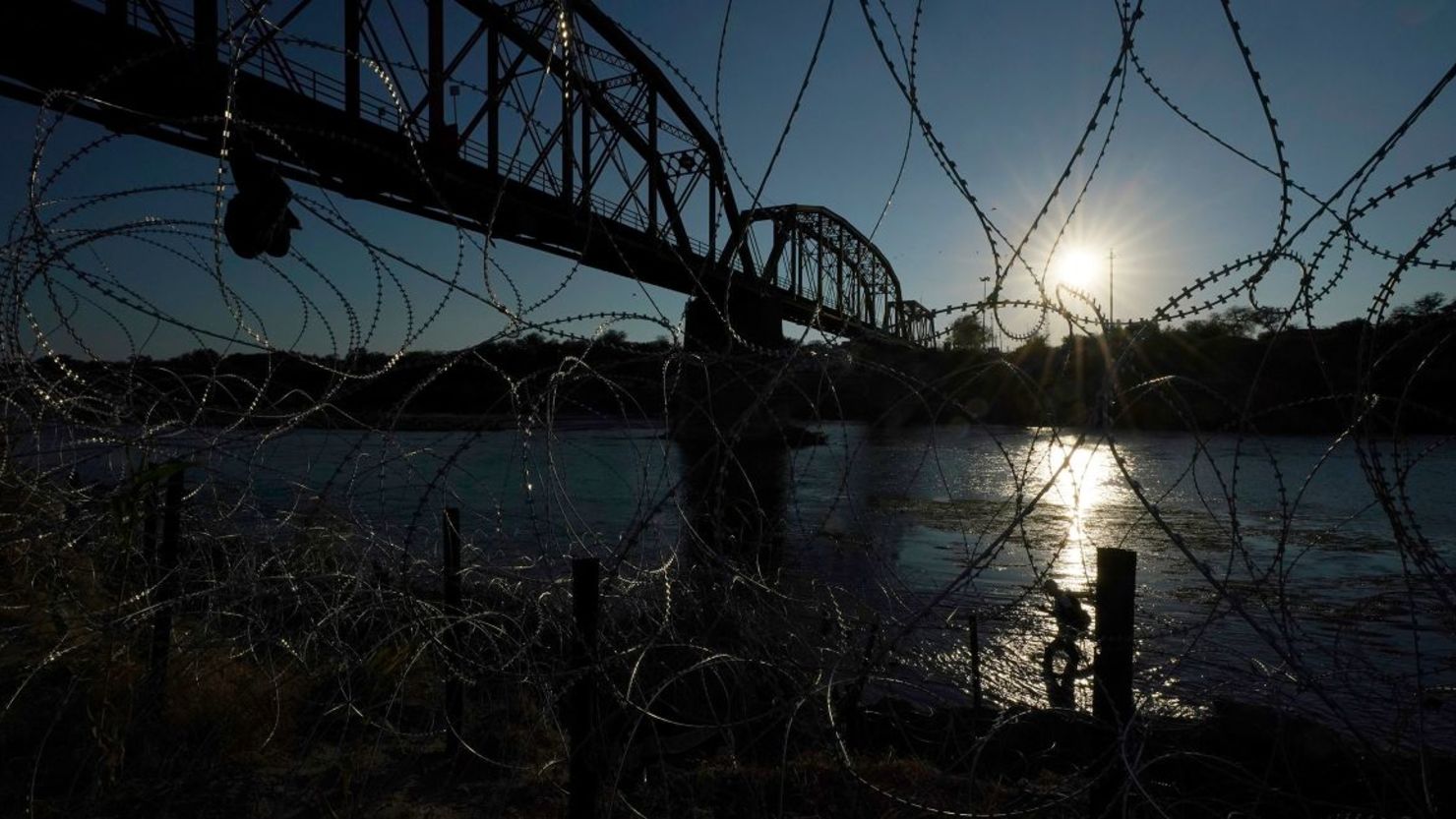 Un migrante camina a lo largo de las orillas del río Grande cerca del Puente Ferroviario Internacional Union Pacific en septiembre en Eagle , Texas.