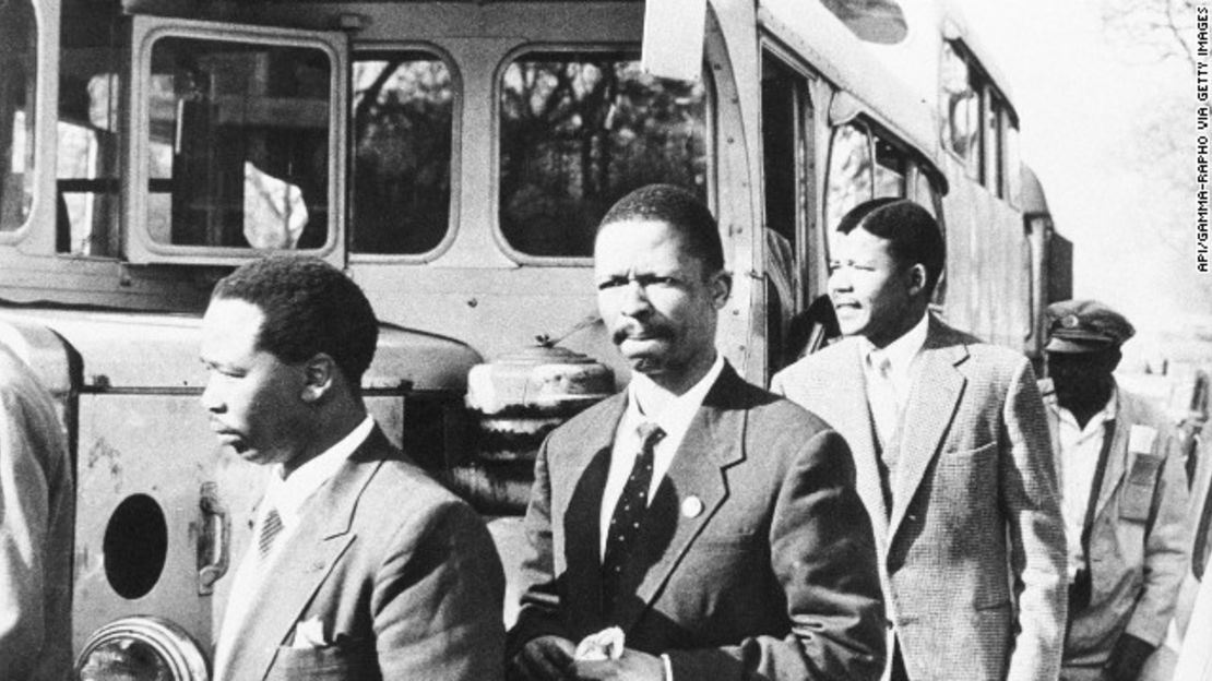 Desde izquierda: Patrick Molaoa, Robert Resha y Mandela caminan hacia la sala del tribunal para su juicio por traición en Johannesburgo.