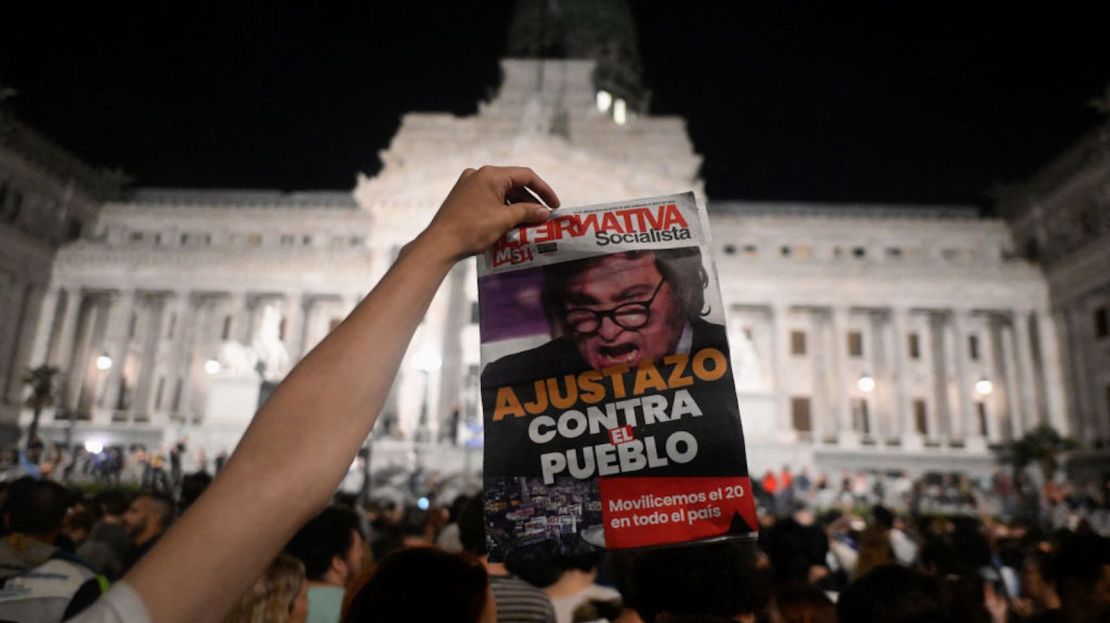 Un hombre muestra un periódico durante una manifestación contra el gobierno del presidente argentino Javier Milei frente al Congreso Nacional, en Buenos Aires el 21 de diciembre de 2023. El nuevo presidente de Argentina dio a conocer el 20 de diciembre de 2023 una serie de medidas para desregular la difícil economía del país, eliminando o cambiando más de 300 normas mediante decreto presidencial, incluidas las relativas a alquileres y prácticas laborales.