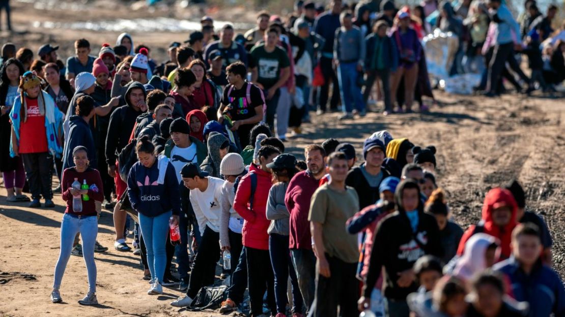 Más de 1.000 migrantes esperan en fila para ser procesados por agentes de la Patrulla Fronteriza de Estados Unidos tras cruzar el Río Grande desde México el 18 de diciembre en Eagle Pass, Texas.Crédito: John Moore/Getty Images