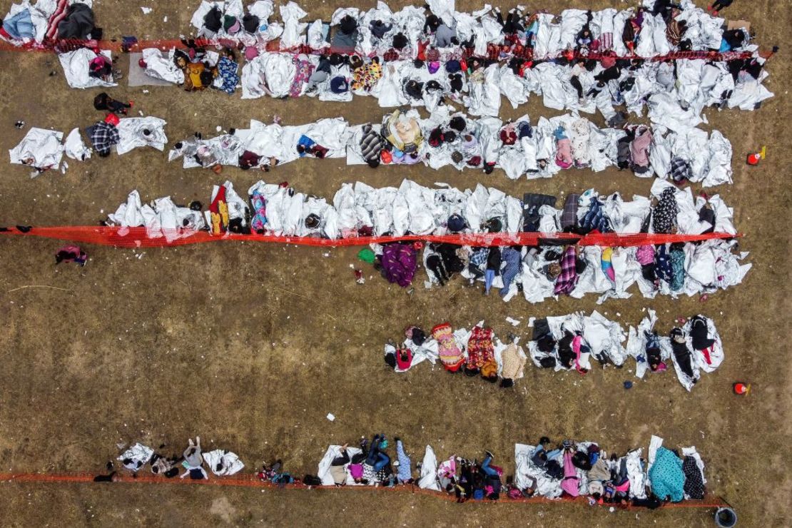 Esta vista aérea muestra a inmigrantes que esperan ser procesados en un centro de tránsito de la Patrulla Fronteriza de Estados Unidos tras cruzar la frontera desde México en Eagle Pass, Texas, el 22 de diciembre de 2023.