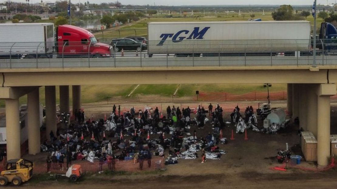 Esta vista aérea muestra a inmigrantes esperando ser procesados en un centro de tránsito de la Patrulla Fronteriza de EE.UU. después de cruzar la frontera desde México en Eagle Pass, Texas, el 22 de diciembre de 2023.