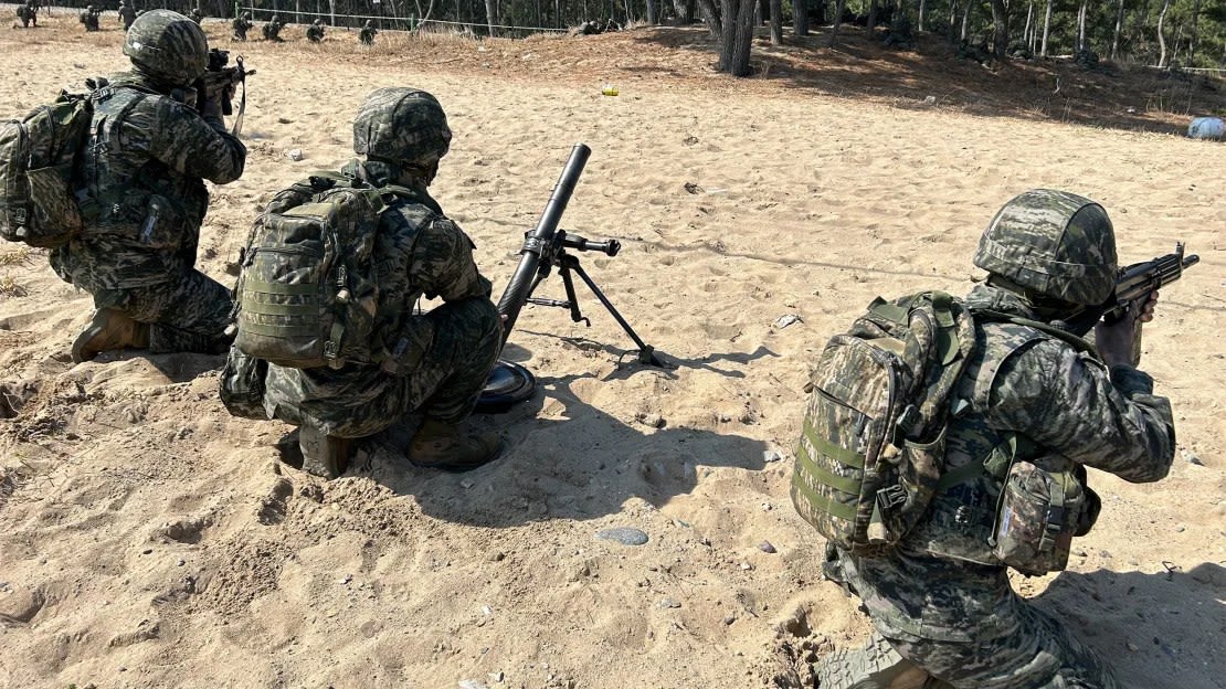 Los marines surcoreanos miran tierra adentro durante un ensayo de desembarco en la playa para el ejercicio Ssang Yong el 28 de marzo en Pohang, Corea del Sur.